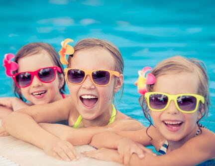 Three smiling girls in swimming pool